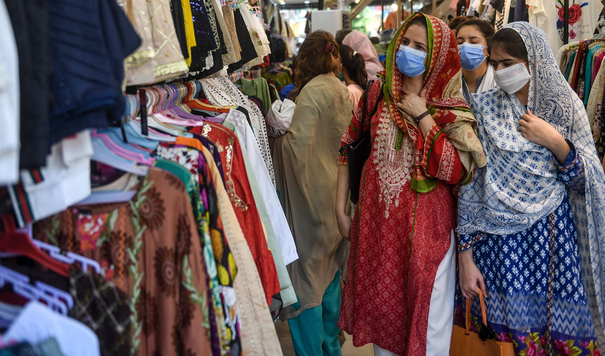People wearing facemasks shop for clothes at a market ahead of the Eid al-Fitr in Karachi on May 20, 2020. (AFP)