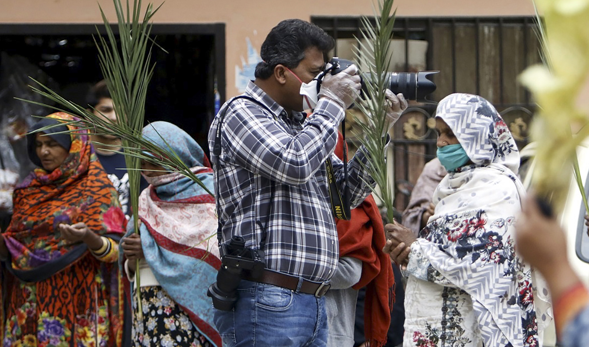 In this picture, AFP photographer Aamir Qureshi covers Christian devotees celebrating a Palm Sunday service in a neighborhood during a government-imposed nationwide lockdown as a preventive measure against the spread of the COVID-19 coronavirus in Islamabad on April 5, 2020. (AFP)