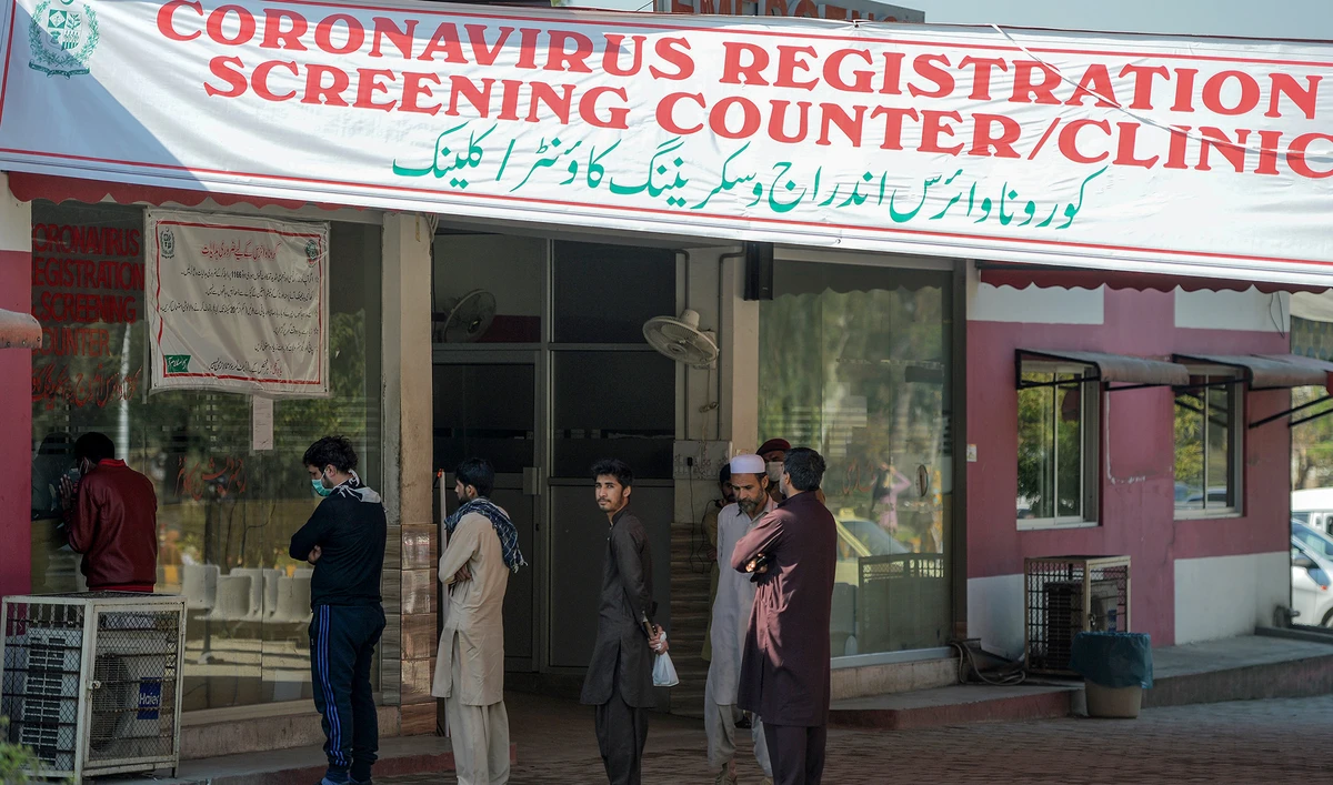 Residents wearing facemasks as a preventive measure against the COVID-19 coronavirus, wait for their turn at a coronavirus registration and screening counter at the Pakistan Institute of Medical Sciences Hospital in Islamabad on March 19, 2020. (AFP)