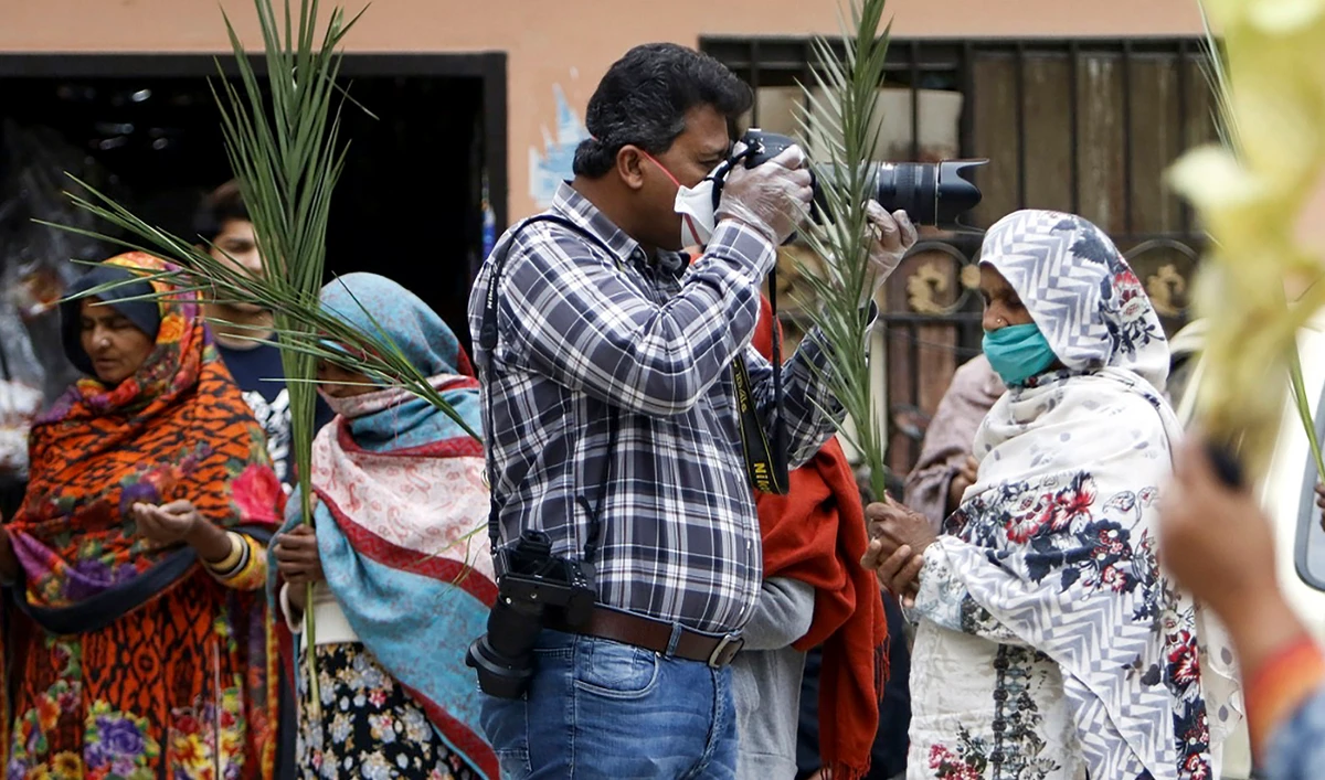 In this picture, AFP photographer Aamir Qureshi covers Christian devotees celebrating a Palm Sunday service in a neighborhood during a government-imposed nationwide lockdown as a preventive measure against the spread of the COVID-19 coronavirus in Islamabad on April 5, 2020. (AFP)