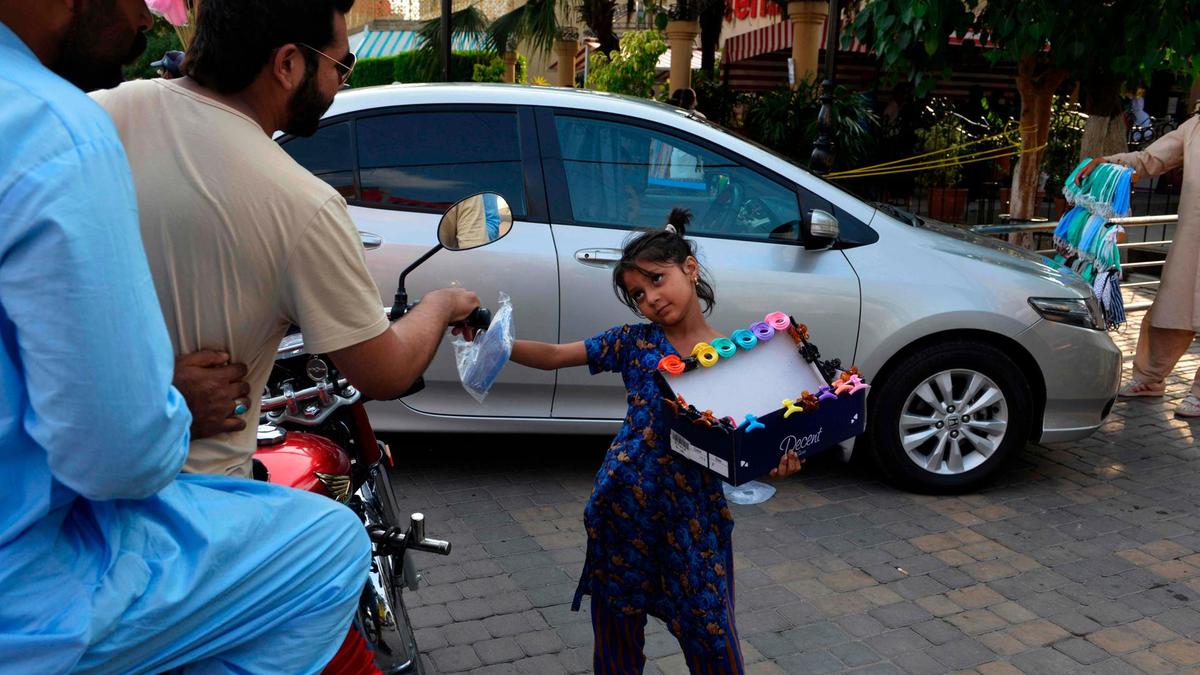 A young girl sells face masks on a street in Rawalpindi on June 2, 2020. (AFP)