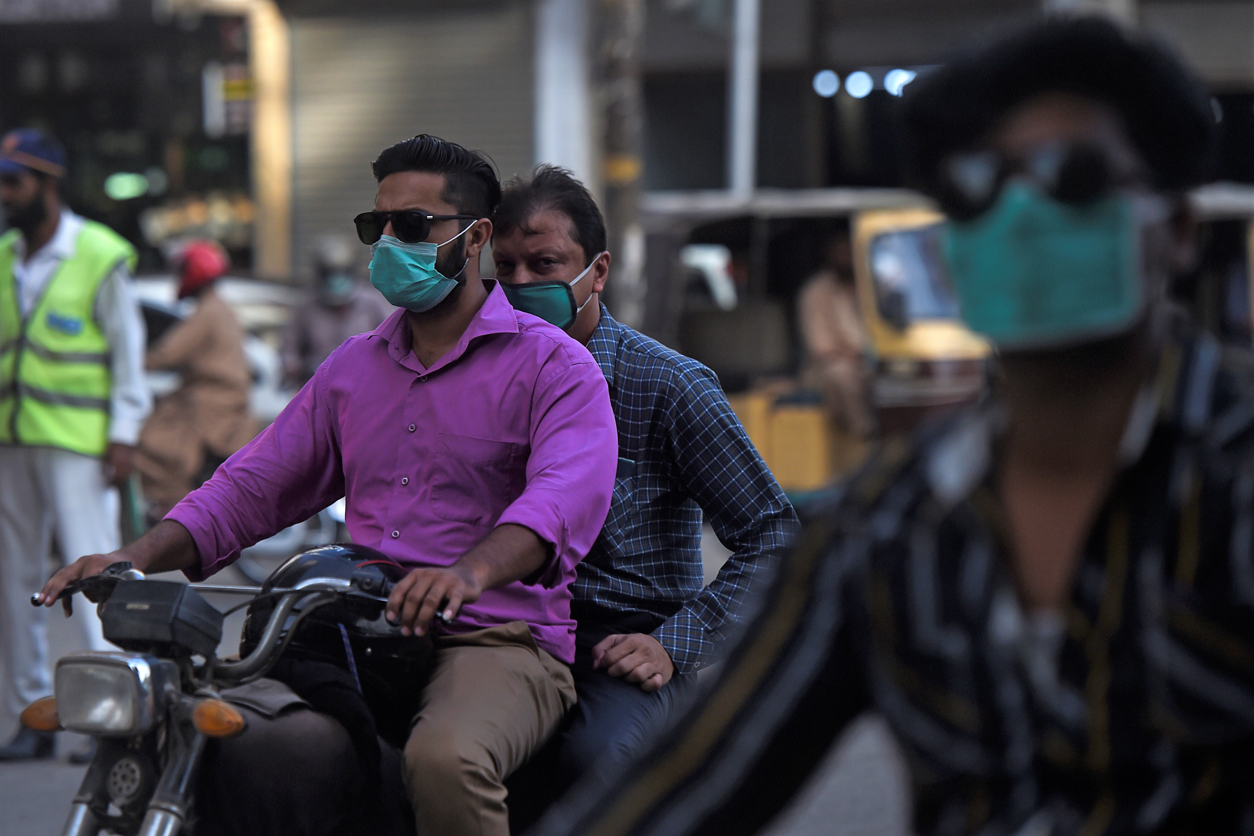 Commuters make their way on a street in Karachi on June 2, 2020. (AFP)))
