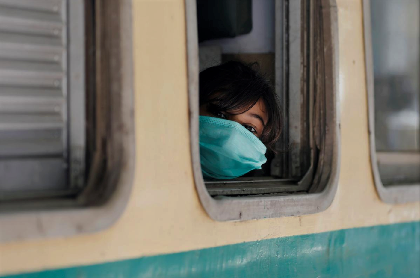 A girl wearing a protective mask looks out from a train window as she returns to her hometown, after Pakistan started easing the lockdown restrictions and allowed to resume passenger trains, following the coronavirus disease (COVID-19) outbreak, in Karachi, Pakistan May 20, 2020. (REUTERS)
