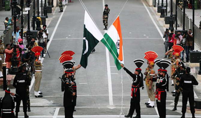 Pakistani Rangers (wearing black uniforms) and Indian Border Security Force (BSF) officers lower their national flags during a parade on Pakistan's 72nd Independence Day, at the Pakistan-India joint check-post at Wagah border, near Lahore, Pakistan on Aug. 14, 2018. (Reuters/File)