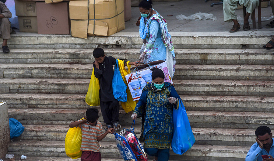 A family leaves after shopping at a market area as COVID-19 coronavirus cases still increase in the country, in Karachi on June 17, 2020. Pakistan, which has recorded 150,000 cases and about 3,000 deaths, Prime Minister Imran Khan resisted a nationwide lockdown, saying the country could ill afford it. (AFP)