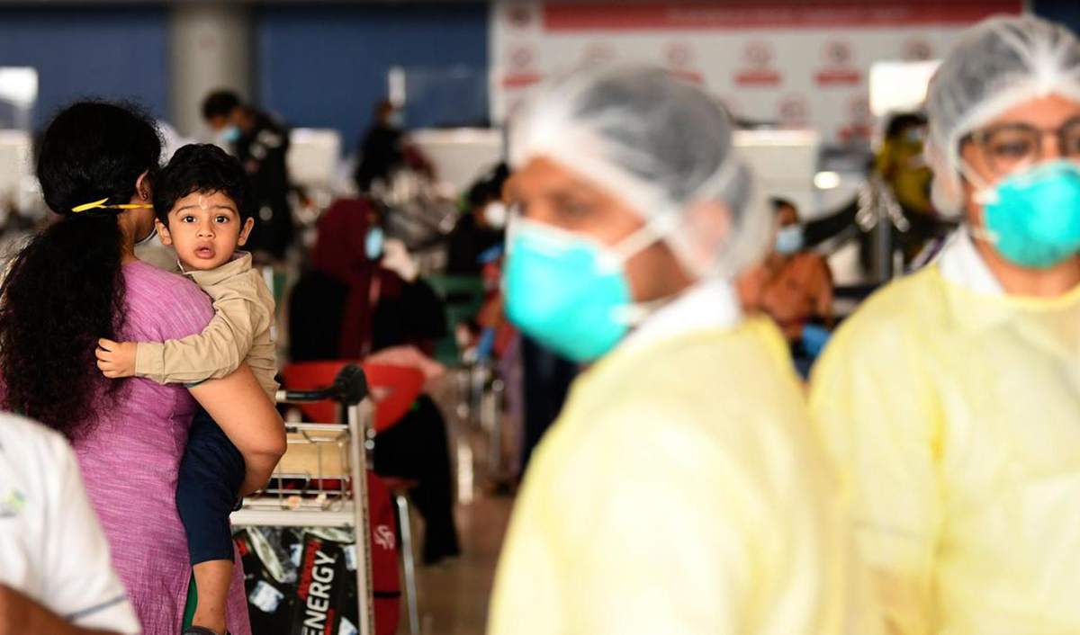 In this file photo, health workers look on as Pakistani nationals check in at the Dubai International Airport before leaving the Gulf Emirate on a flight back to their country, on May 7, 2020. (AFP)