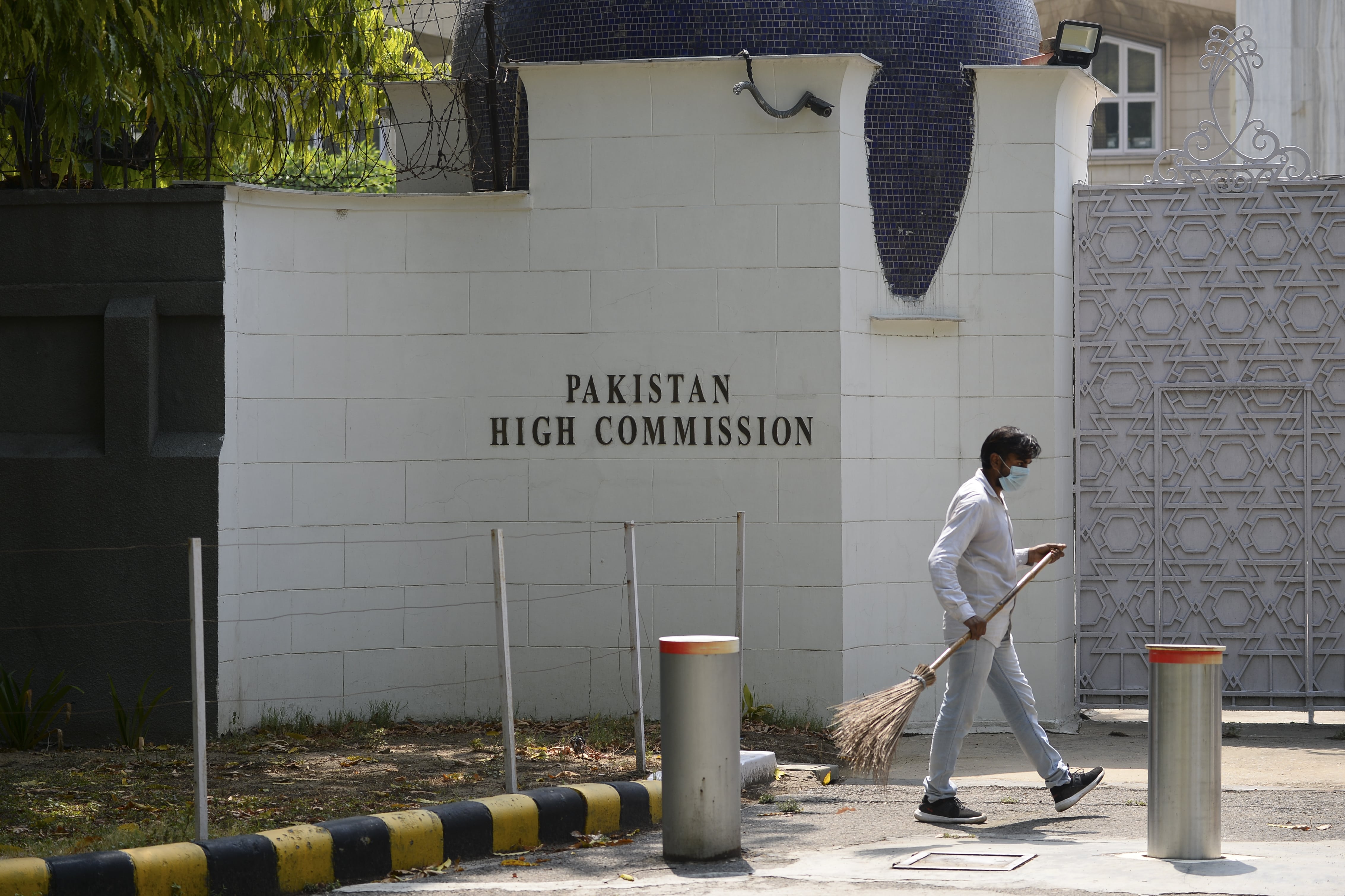 A man sweeps in front of the main gate of the Pakistan High Commission in New Delhi on June 1, 2020. (AFP)