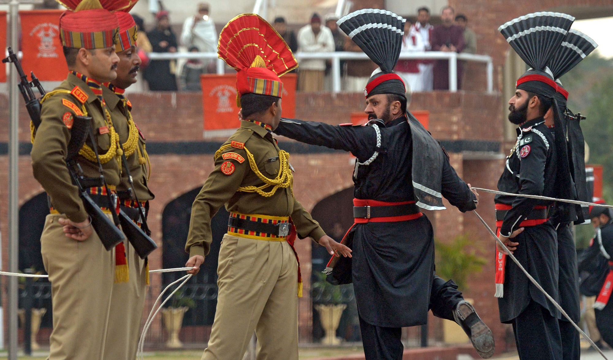 In this file photo, Indian Border Security Force personnel wearing brown uniforms and Pakistani Rangers wearing black uniforms take part in the Beating Retreat ceremony at the India-Pakistan Wagah border post on Jan. 22, 2019. (AFP)