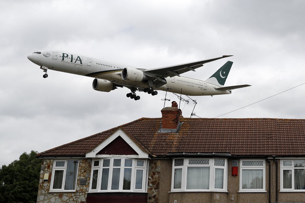 A Pakistan International Airlines (PIA) Boeing 777 comes in over houses to land at Heathrow Airport in west London on June 8, 2020. (AFP)