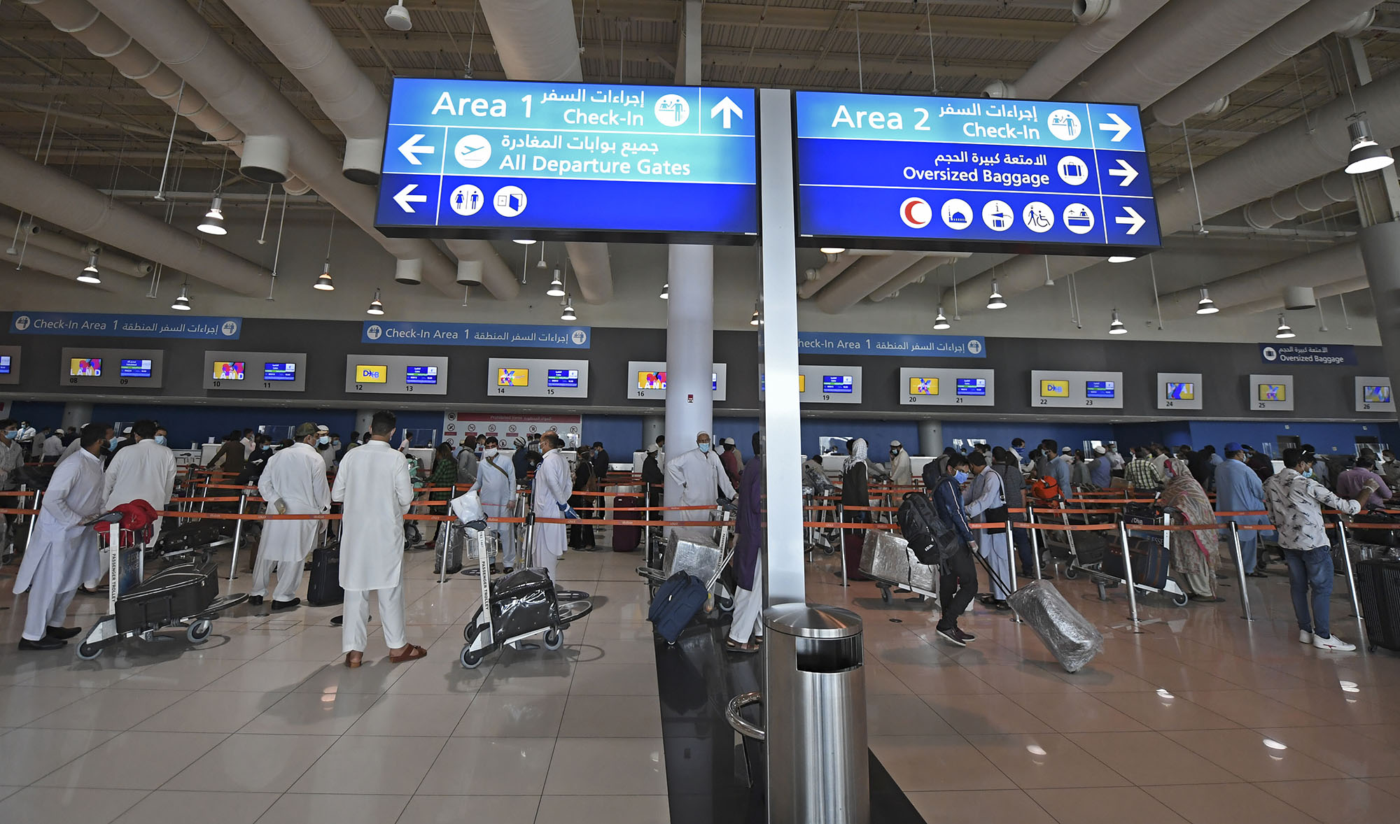 In this file photo, Pakistani nationals check in at the Dubai International Airport before leaving the Gulf Emirate on a flight back to their country, on May 7, 2020, amid the novel coronavirus pandemic crisis. (AFP)