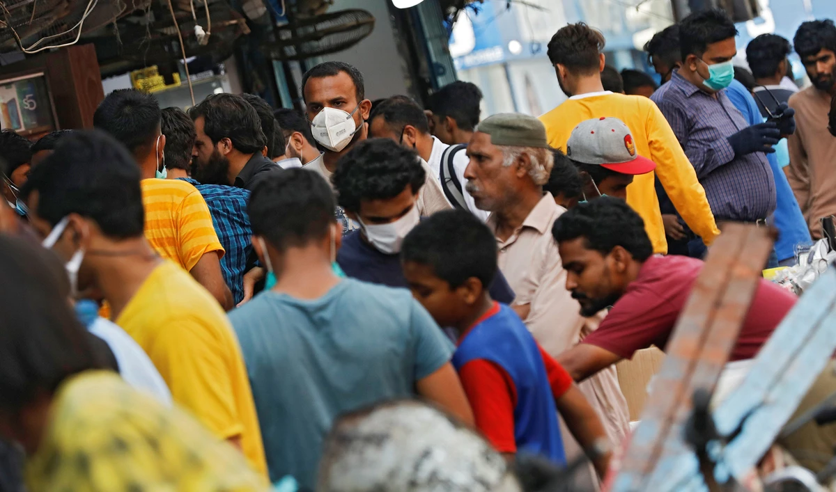 A man wearing a protective face mask walks amidst the rush of people outside an electronics market, after Pakistan started easing the lockdown restrictions, as the outbreak of the coronavirus disease (COVID-19) continues, in Karachi on June 4, 2020. (REUTERS)