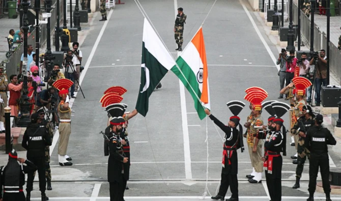Pakistani Rangers (wearing black uniforms) and Indian Border Security Force (BSF) officers lower their national flags during a parade on Pakistan's 72nd Independence Day, at the Pakistan-India joint check-post at Wagah border, near Lahore, Pakistan on Aug. 14, 2018. (Reuters/File)
