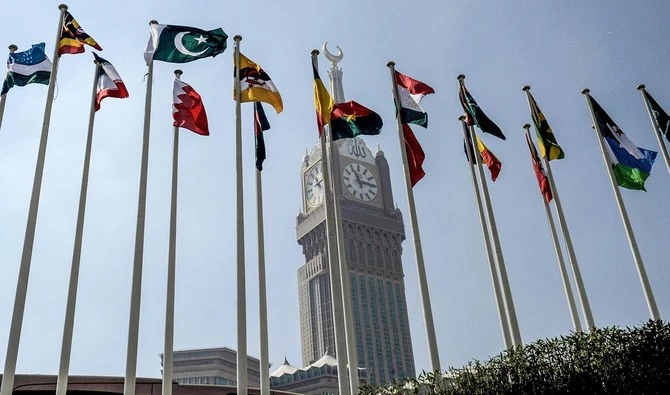 This file photo shows the national flags of the members of Organisation of Islamic Cooperation (OIC) states flying in front of the clock of the Abraj al-Bait Towers in Makkah on Nov. 17, 2019. (AFP)