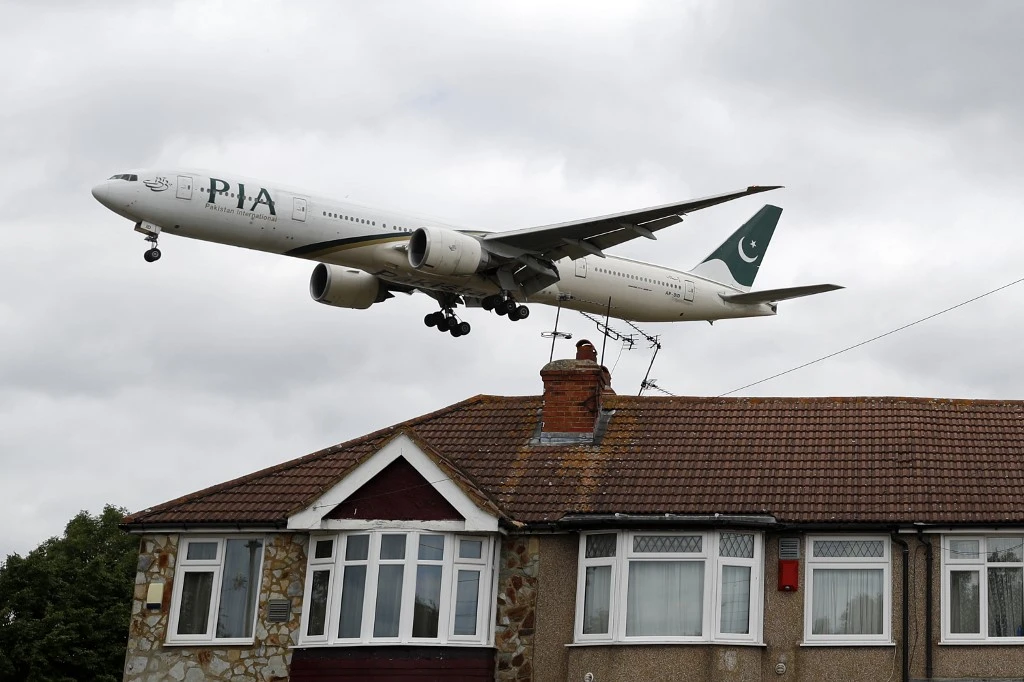 A Pakistan International Airlines (PIA) Boeing 777 comes in over houses to land at Heathrow Airport in west London on June 8, 2020. (AFP)