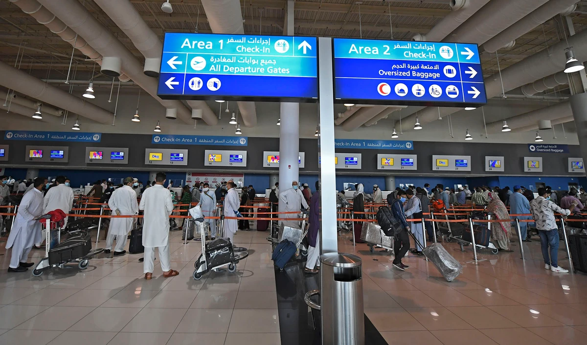 In this file photo, Pakistani nationals check in at the Dubai International Airport before leaving the Gulf Emirate on a flight back to their country, on May 7, 2020, amid the novel coronavirus pandemic crisis. (AFP)