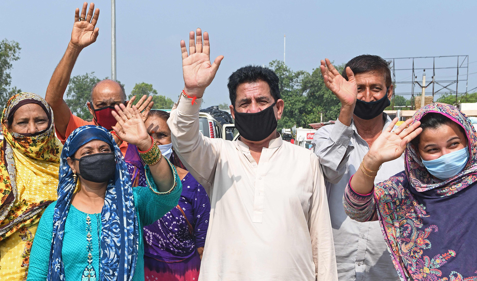 Pakistani nationals, who were previously stranded in India following the closure of borders due to the COVID-19 coronavirus lockdown, wave before crossing through the India-Pakistan Wagah border post on July 9, 2020. (AFP)