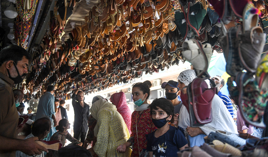 In this picture taken on May 20, 2020, people shop for shoes at a market in Karachi, Pakistan. (AFP Photo)