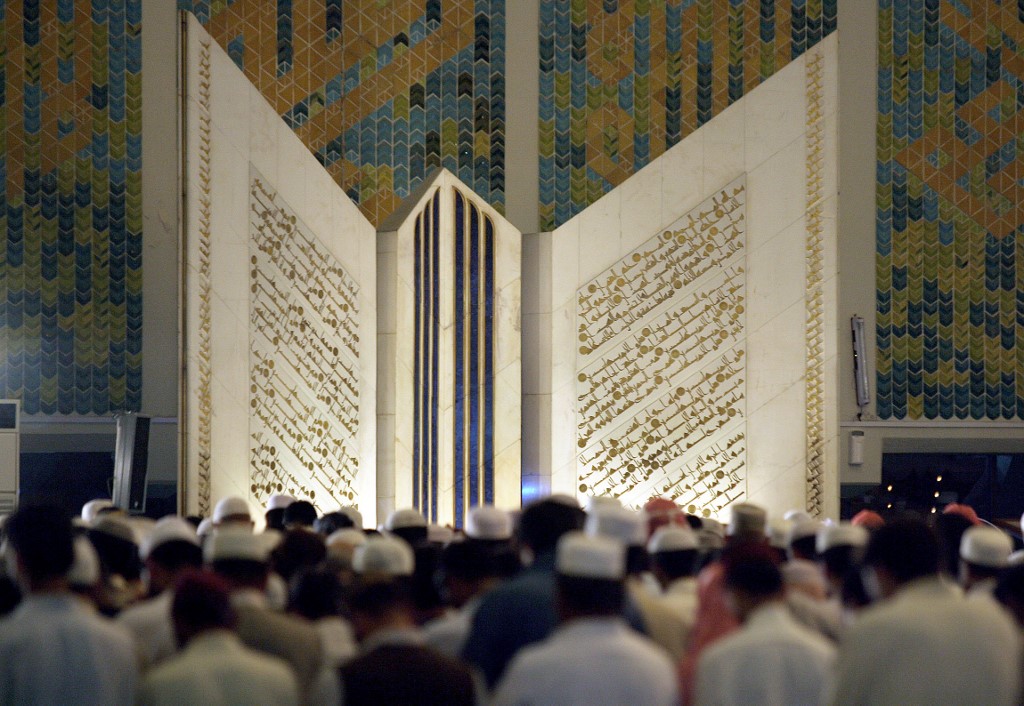 Pakistani Muslims offer prayers in front of the giant Qur'an at the Faisal Mosque in Islamabad, Oct. 20, 2006. (AFP/File)