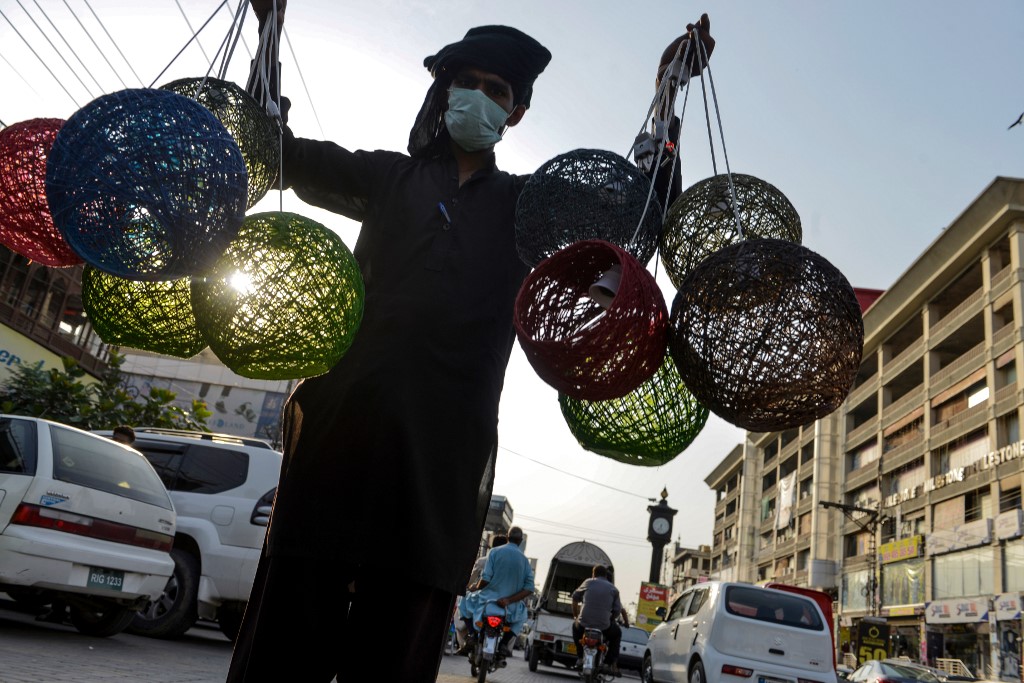 A street vendor sells colored lampshades on a road near a market in Rawalpindi, Pakistan, on June 10, 2020. (AFP)