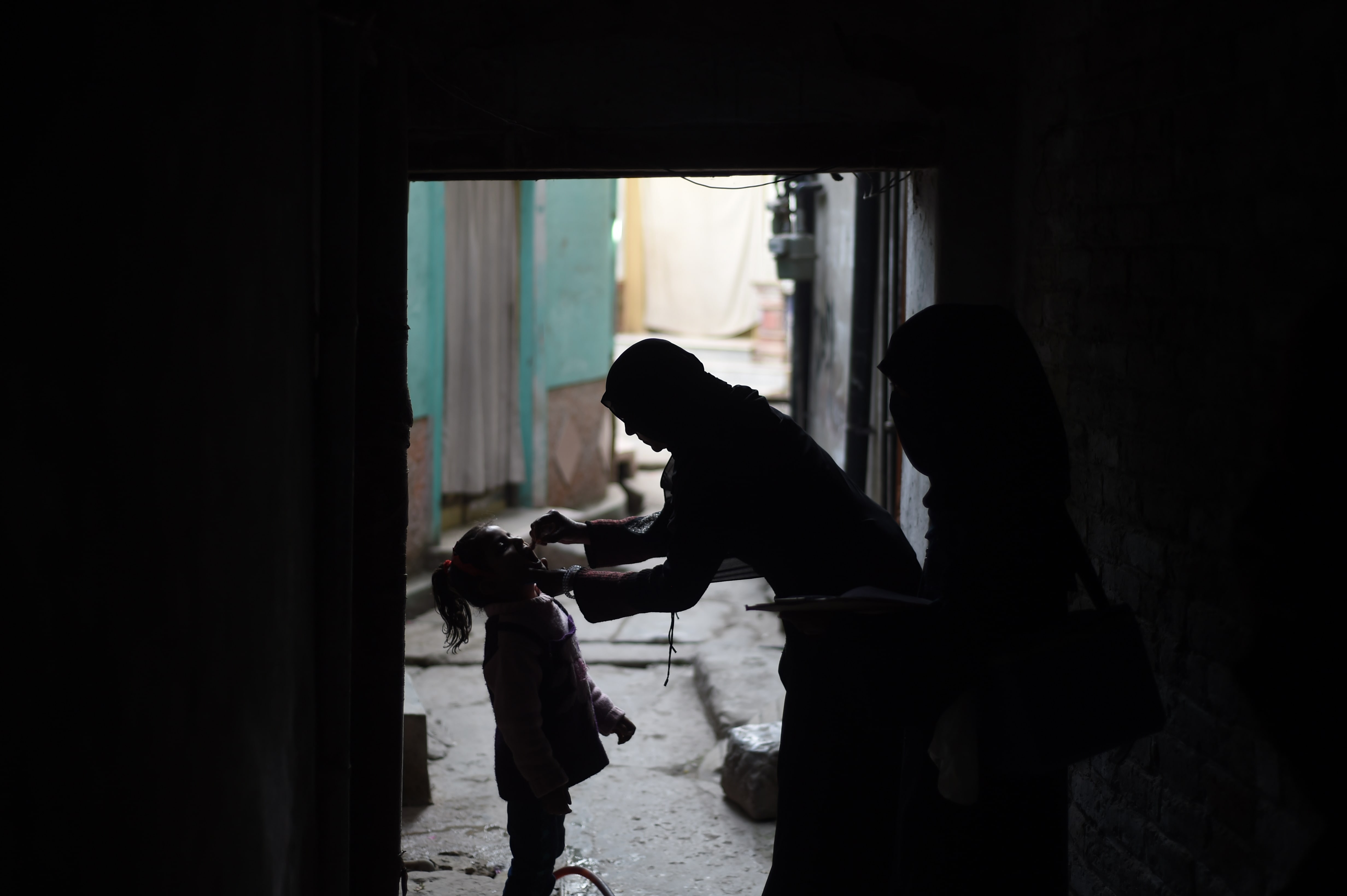 A Pakistani health worker (R) administers the polio vaccine to a child during a vaccination campaign in Rawalpindi on December 9, 2014. (AFP Photo)