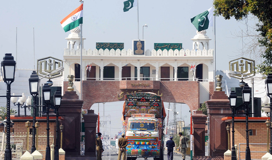 Indian and Pakistani national flags flutter as Indian Border Security Force (BSF) personnel (L) and Pakistani Rangers (R) allow a Pakistani truck to cross over to India at the Wagah Border India on February 24, 2010. (AFP)