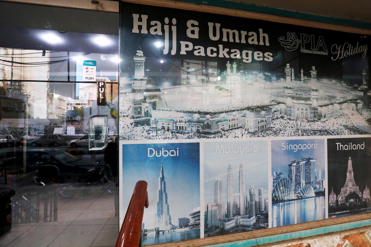 A sign promotes airline's Haj and Umrah packages outside a ticketing office, as the spread of the coronavirus disease (COVID-19) continues, in Karachi, Pakistan July 6, 2020. (REUTERS)