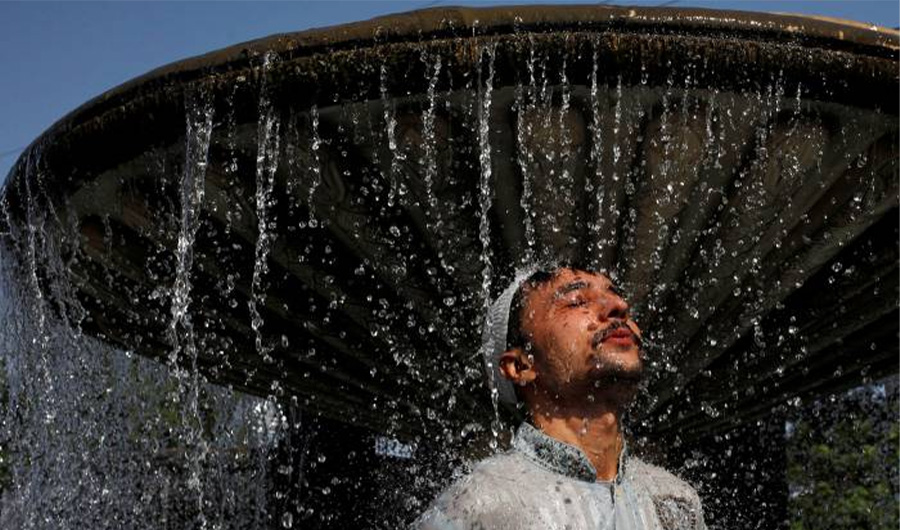 A man cools off from the heatwave, as he takes a shower at a water fountain along a road in Karachi, Pakistan May 25, 2018. (REUTERS)
