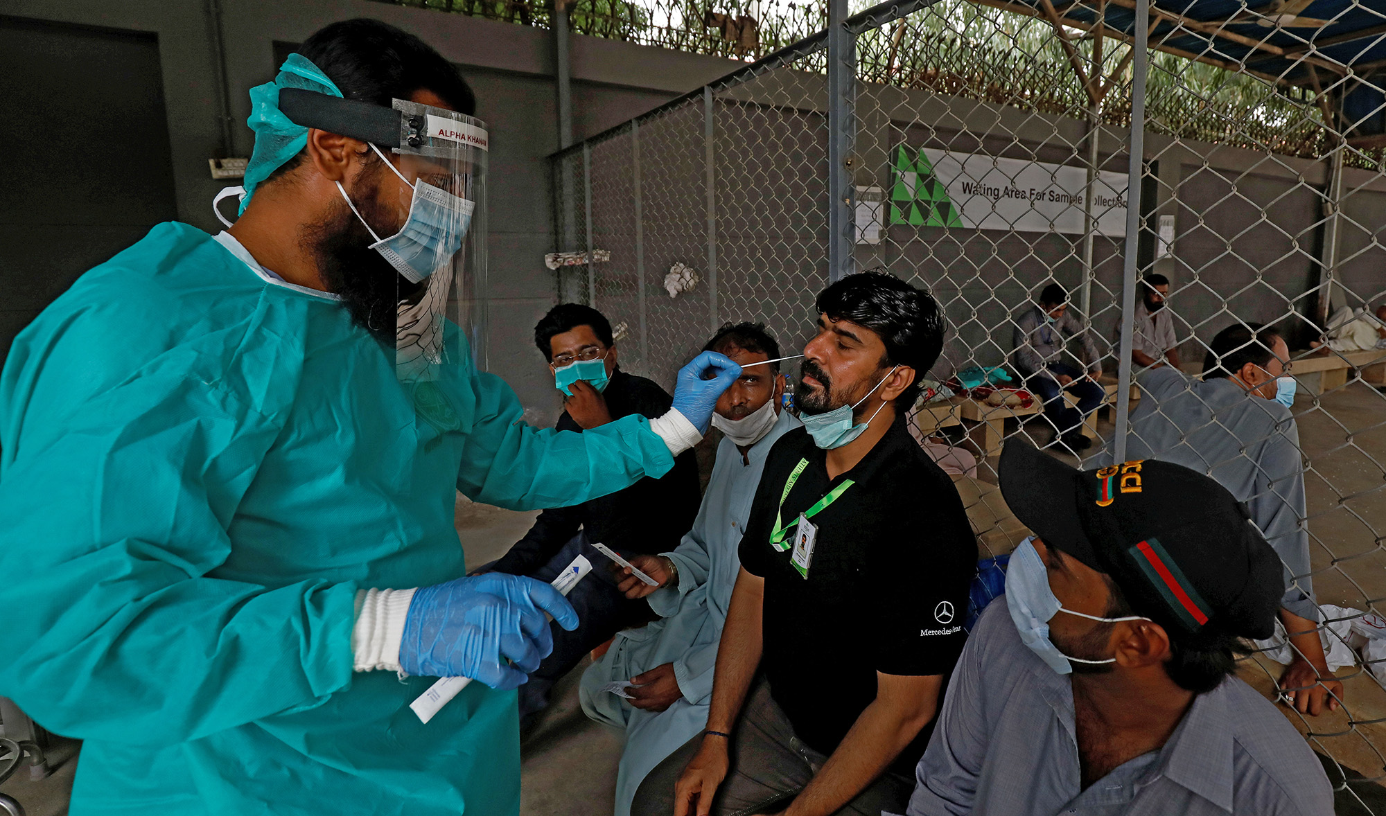 A paramedic wearing protective gear takes a nasal swab from a man, to be tested for the coronavirus disease (COVID-19), in Karachi on July 13, 2020. (REUTERS)