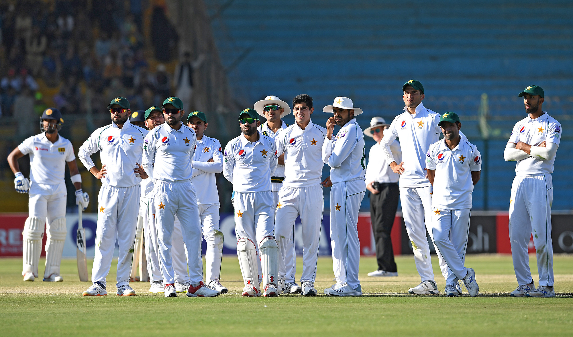 In this file photo, Pakistan's cricketers wait for the umpire's decision during a Test cricket match between Pakistan and Sri Lanka at the National Cricket Stadium in Karachi on Dec. 22, 2019. Pakistan’s cricket team will leave for its tour of England on Sunday without 10 players, who were tested positive for COVID19 for the second time, says PCB. (AFP)