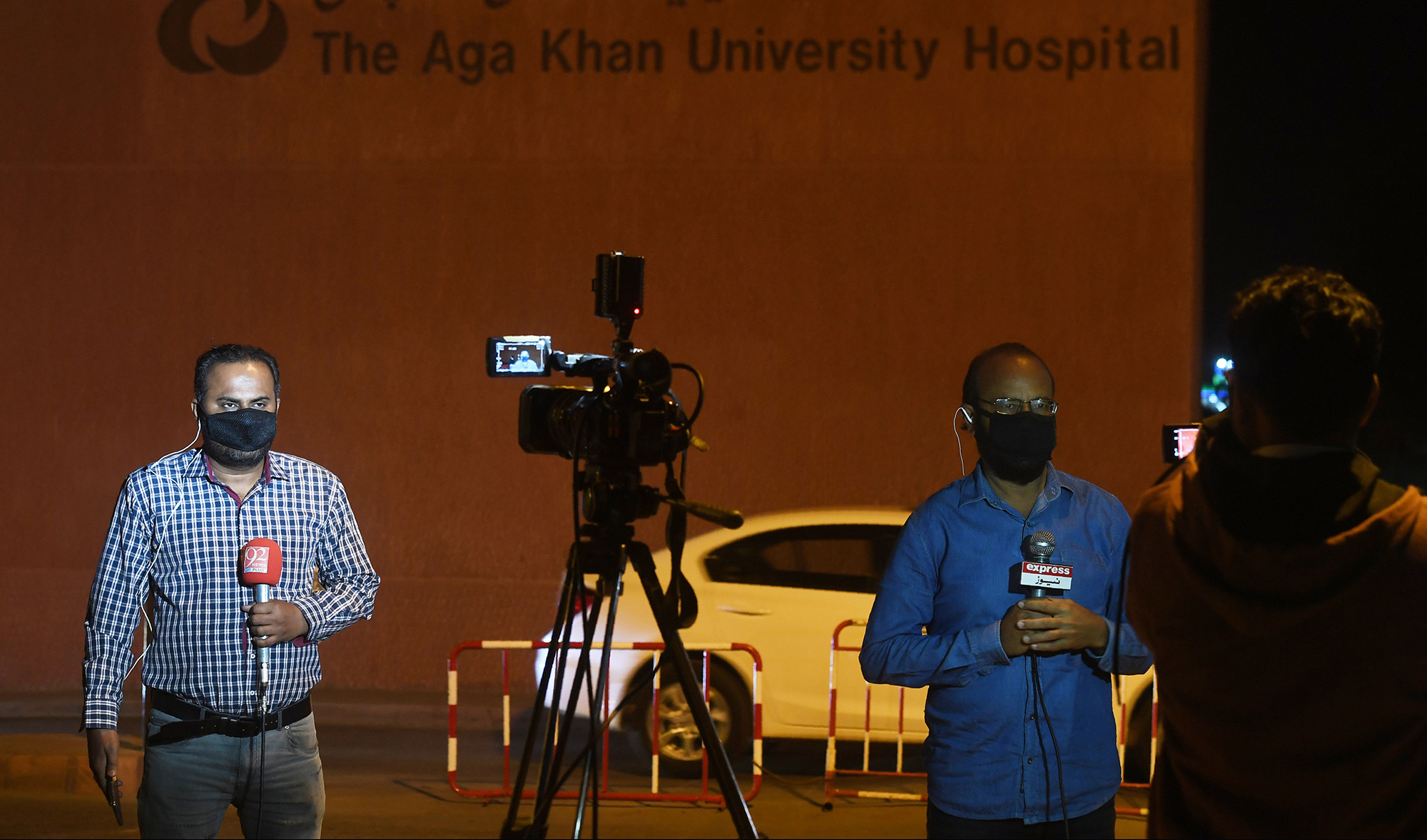 In this file photo, Pakistani journalists wearing protective facemasks report outside the Aga Khan University Hospital where a patient of the COVID-19 novel coronavirus has been admitted in Karachi on Feb. 26, 2020. (AFP)