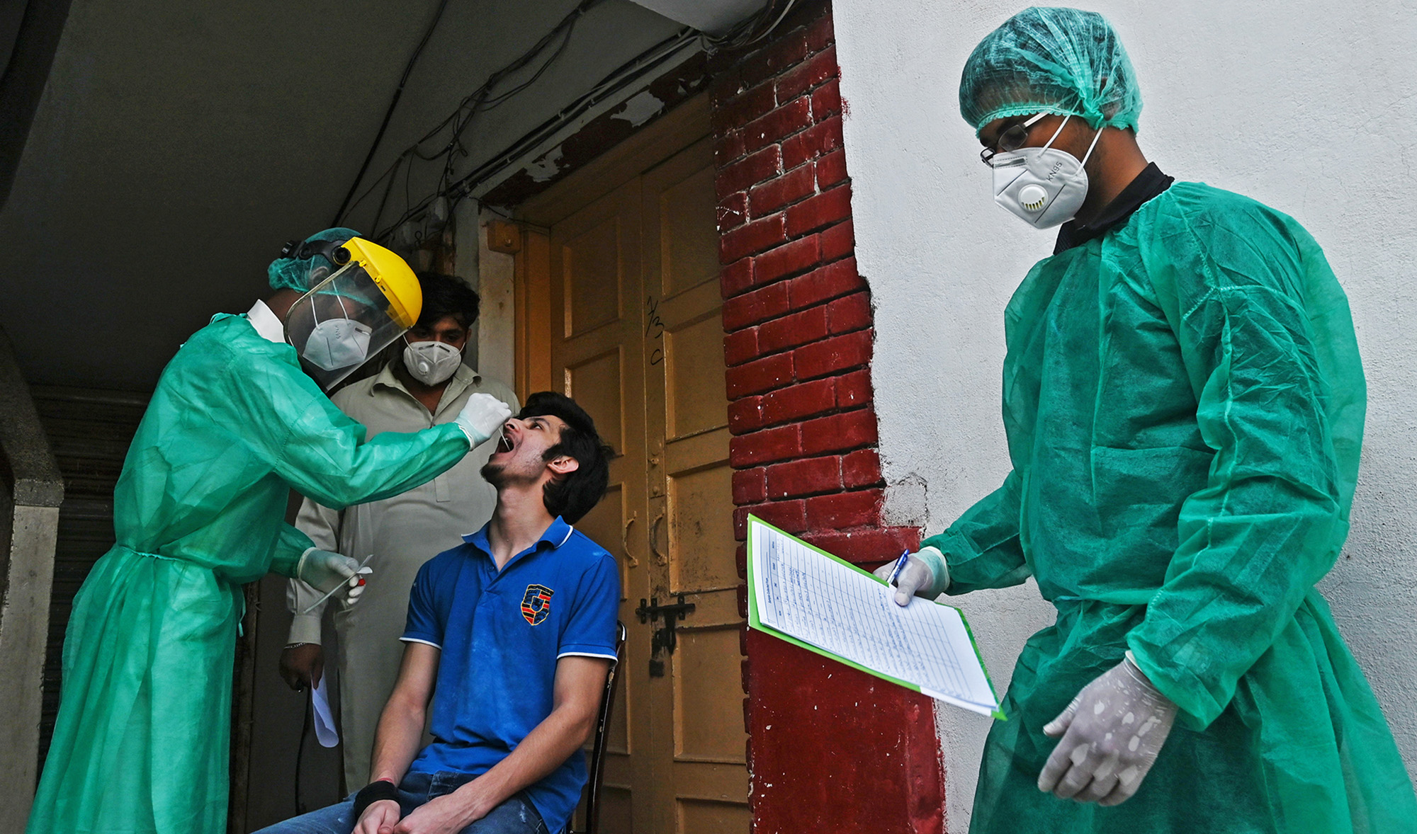 In this file photo, a health official wearing Personal Protective Equipment (PPE) takes a swab sample from a man during door to door a screening and testing for the COVID-19 coronavirus at a restricted area sealed by the authorities in Islamabad on June 29, 2020. (AFP)