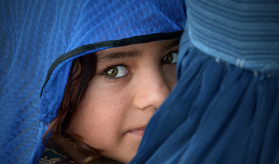 In this file photo, an Afghan woman carries her girl at the Azakhel Voluntary Repatriation Centre in Nowshera, Khyber Pakhtunkhwa, on Sept. 8, 2018. (AFP)