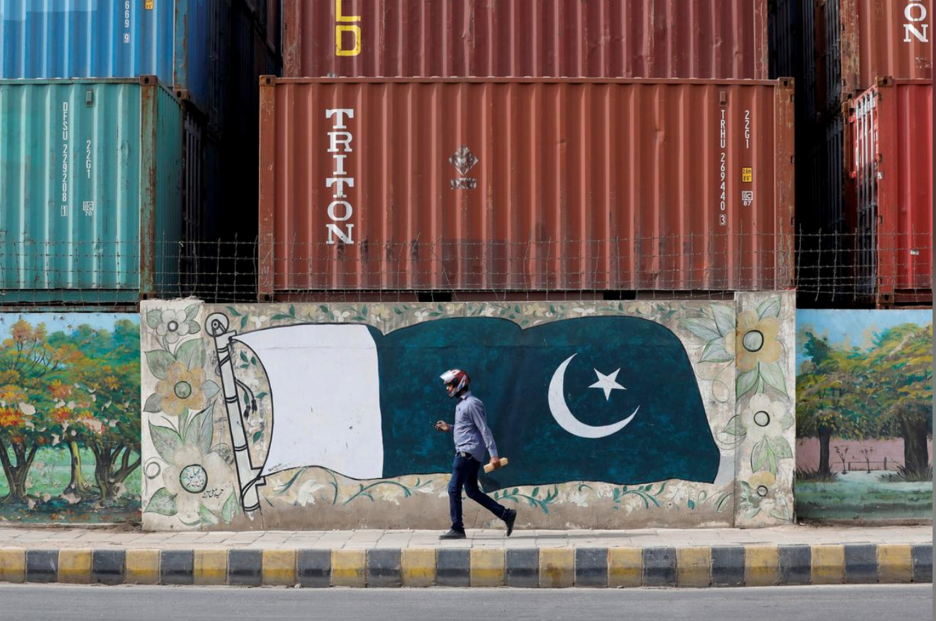 A man walks past a wall of a shipping container's yard painted with a national flag in Karachi, Pakistan August 6, 2018. (REUTERS/ File)