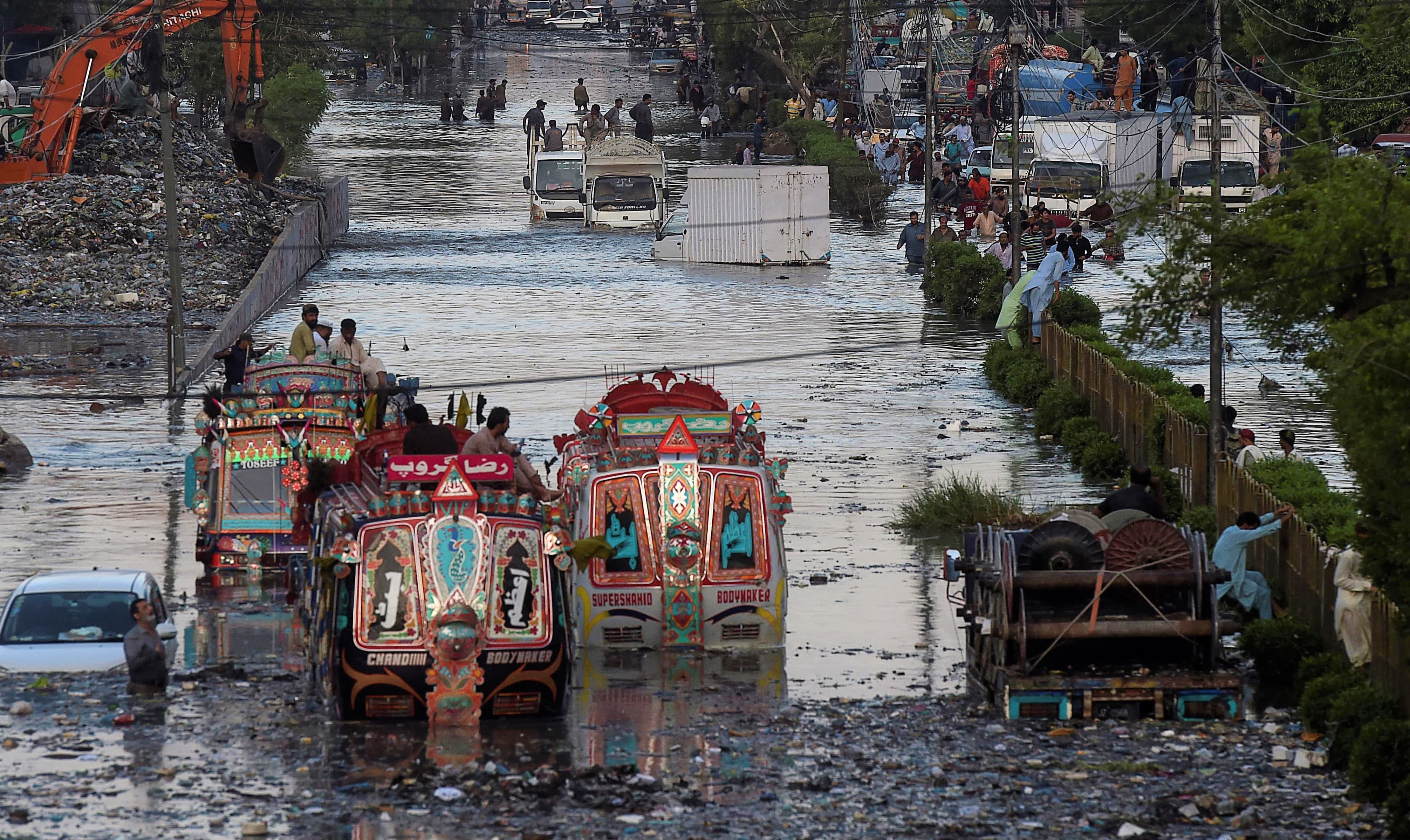 Passenger buses are stuck in flooded water on a street after heavy monsoon rains in the Pakistan's port city of Karachi on July 27, 2020. (AFP photo)