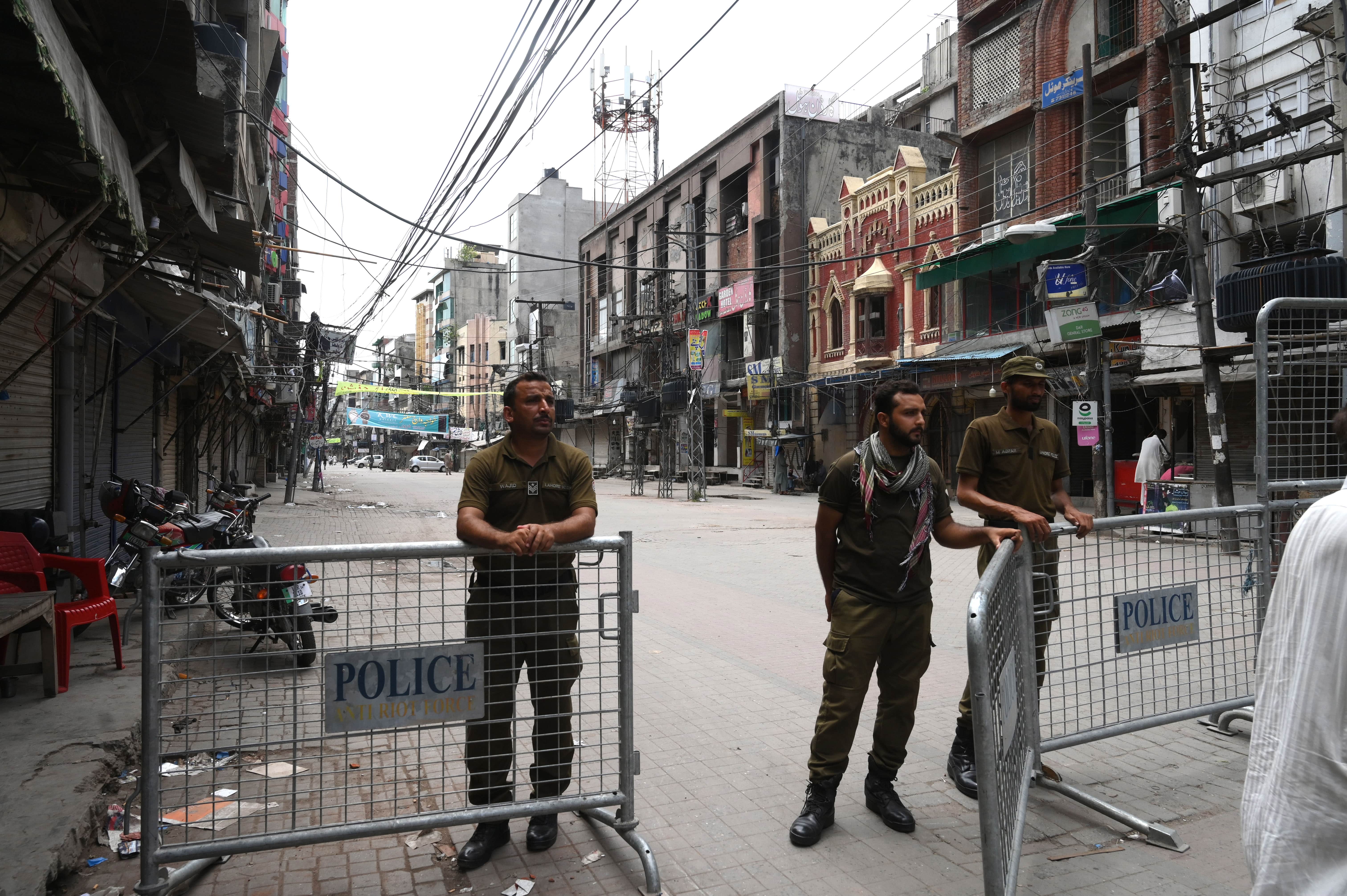 Police stand at a barricade at the entrance of a closed market in Lahore on July 30, 2020. (AFP)