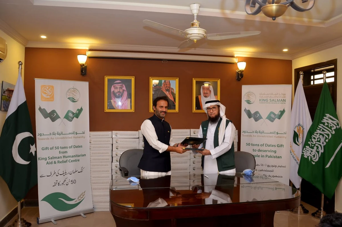 Dr. Khalid Muhammad Al-Othmani, Director KSRelief Pakistan, and Aon Abbas Buppi, Managing Director Pakistan Bait-ul-Mal, are signing a Memorandum of Understanding in Islamabad for the distribution of 36 tons of dates provided by the Saudi relief agency on July 2, 2020. (Photo courtesy: KSRelief)