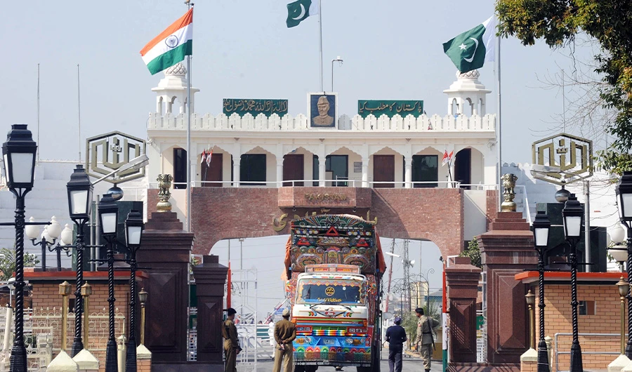 Indian and Pakistani national flags flutter as Indian Border Security Force (BSF) personnel (L) and Pakistani Rangers (R) allow a Pakistani truck to cross over to India at the Wagah Border India on February 24, 2010. (AFP)