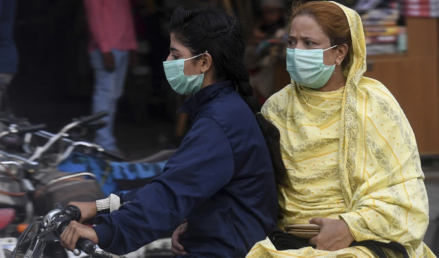 Women wearing facemasks ride on a motorbike in Karachi, Pakistan, on June 8, 2020. Provincial authorities across the country have banned pillion riding amid other measures taken to prevent the spread of coronavirus. (AFP)
