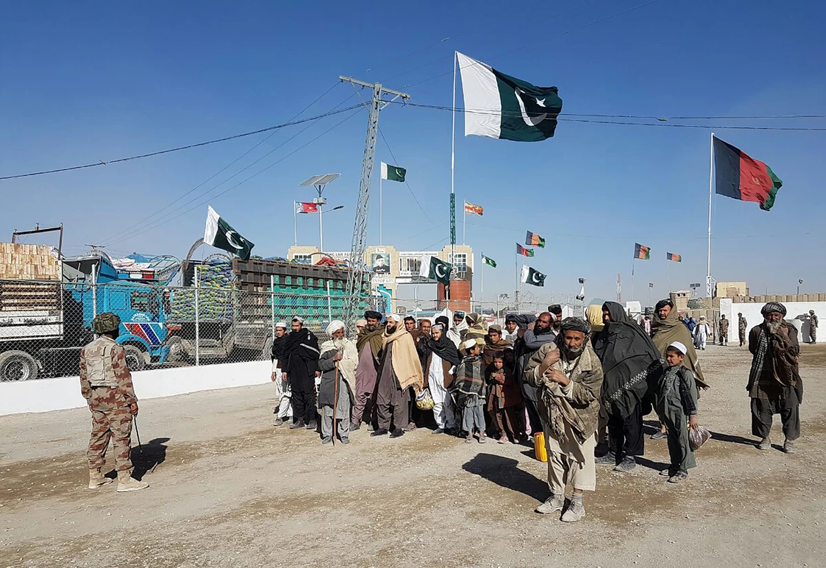 In this photograph taken on January 7, 2017, travellers are watched by Pakistan security personnel as they wait to cross the border between Pakistan and Afghanistan at Chaman. (AFP)