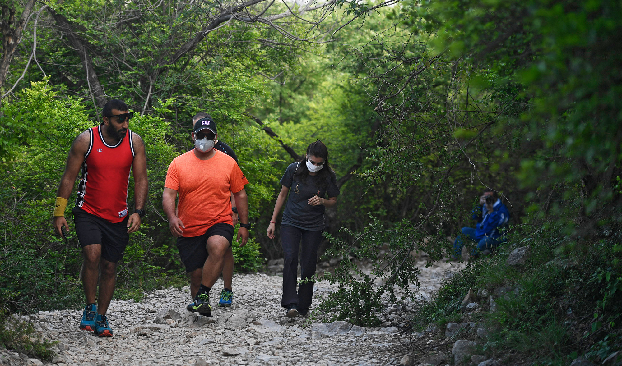Residents wearing facemasks walk on a hiking trail on Margalla Hill during a government-imposed nationwide lockdown against COVID-19, Islamabad on April 29, 2020. Parks and hiking trails in the Margalla Hills have been opened to the public for the purpose of exercising. (AFP/File)