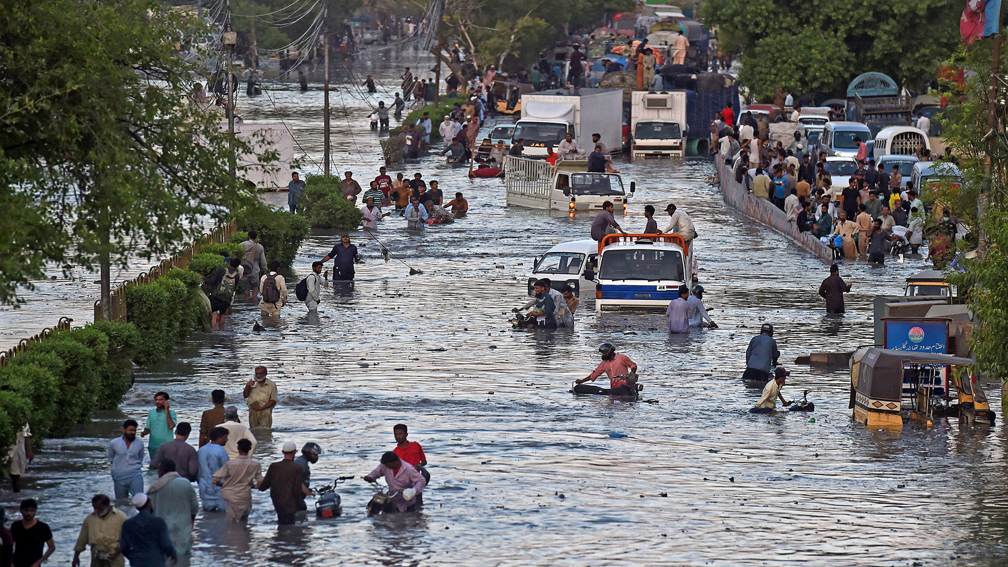 Commuters cross a flooded street after heavy monsoon rains in the Pakistan's port city of Karachi on July 27, 2020. (AFP/File)