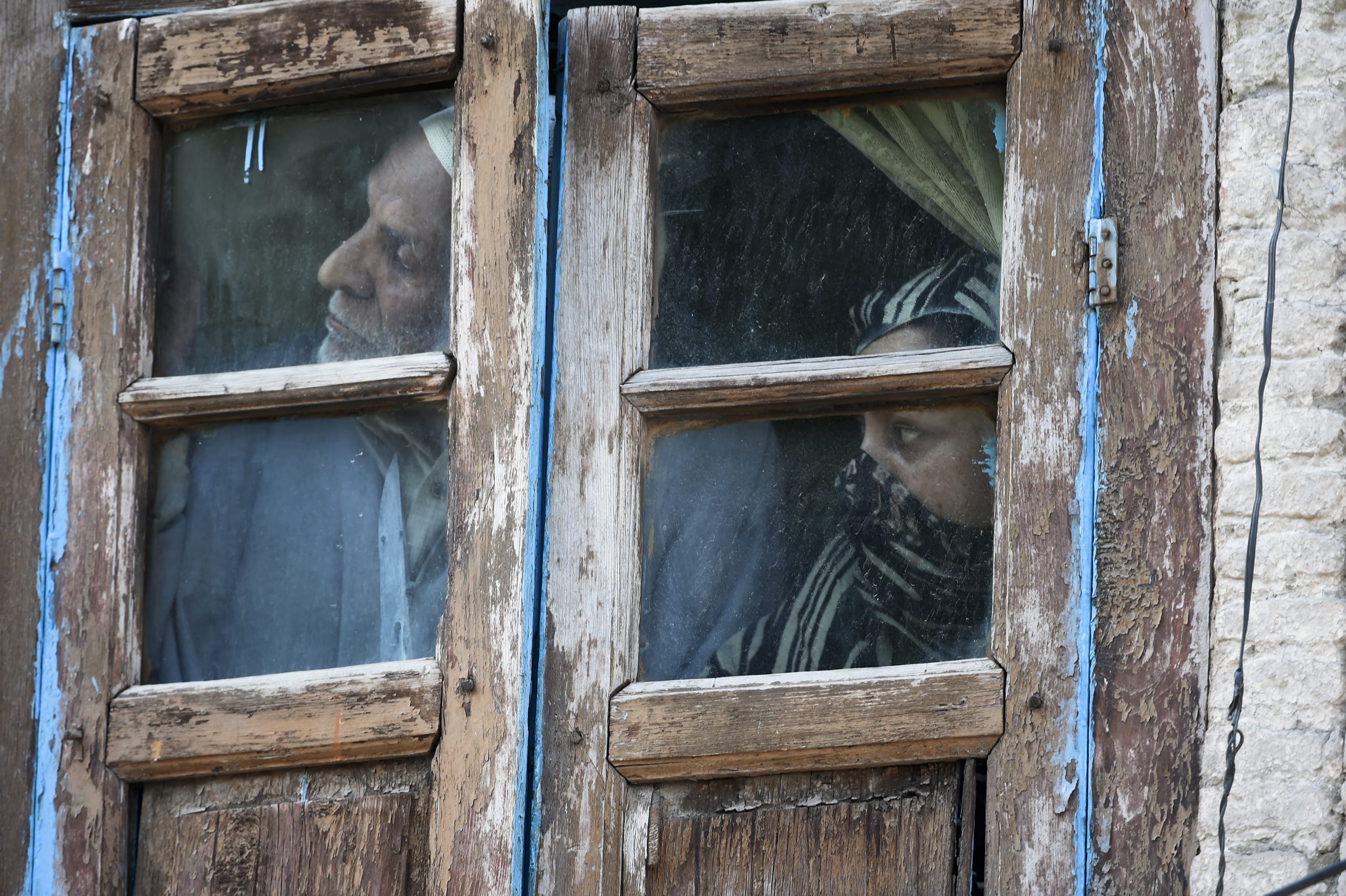 Residents watch out from their window in an area near the site of a gun battle between suspected militants and Indian forces in Srinagar, Kashmir on May 19, 2020. ( AFP/ File Photo)