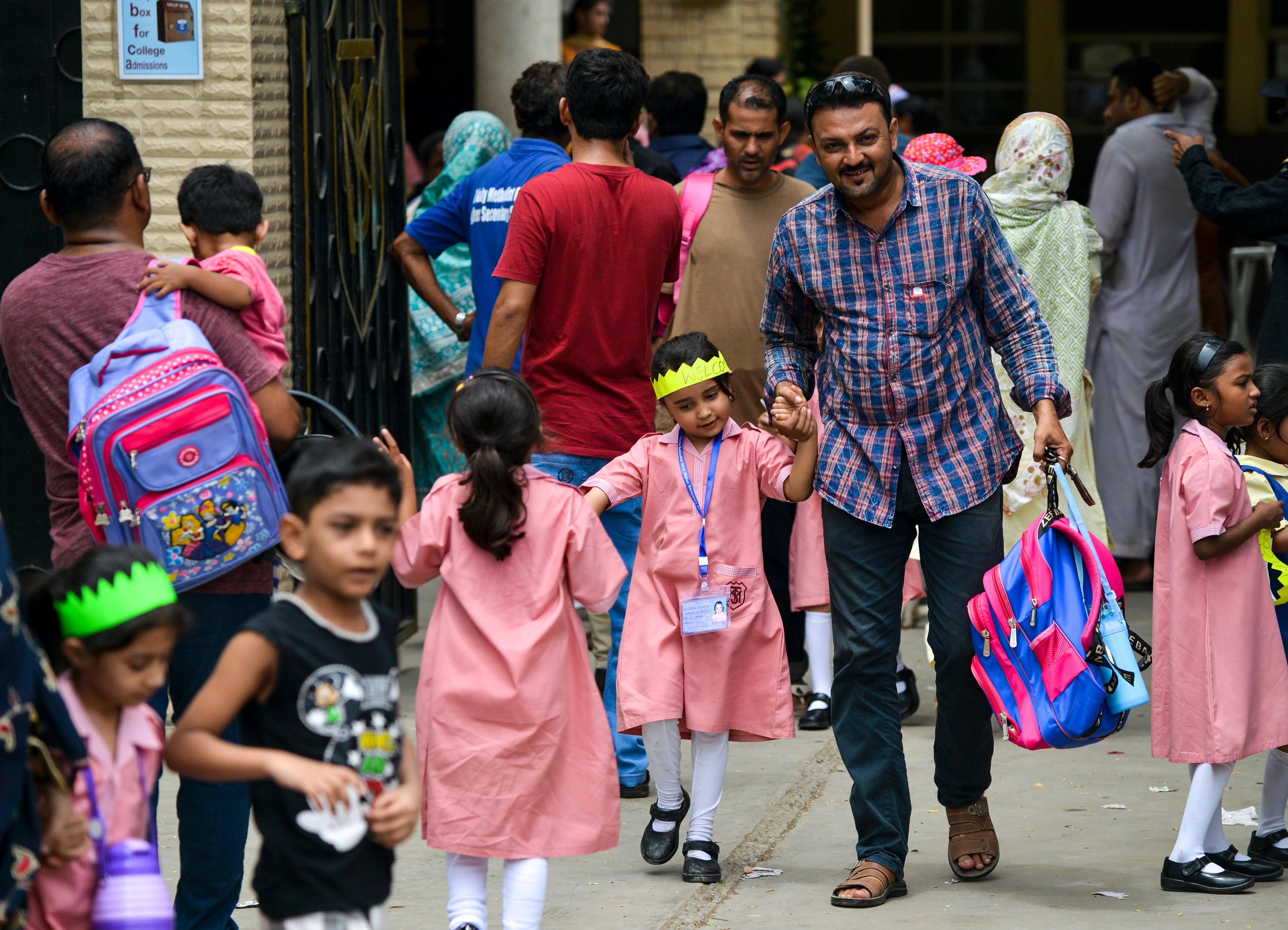 Pakistani pupils leave with their parents on the first day of school after the summer vacation in Karachi on July 1, 2019. (AFP)