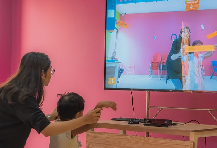 In this undated photo, a woman helps a child play a game designed by WonderTree, a startup that makes augmented reality games for the therapy and education of children with special needs. (Photo courtesy: WonderTree website)