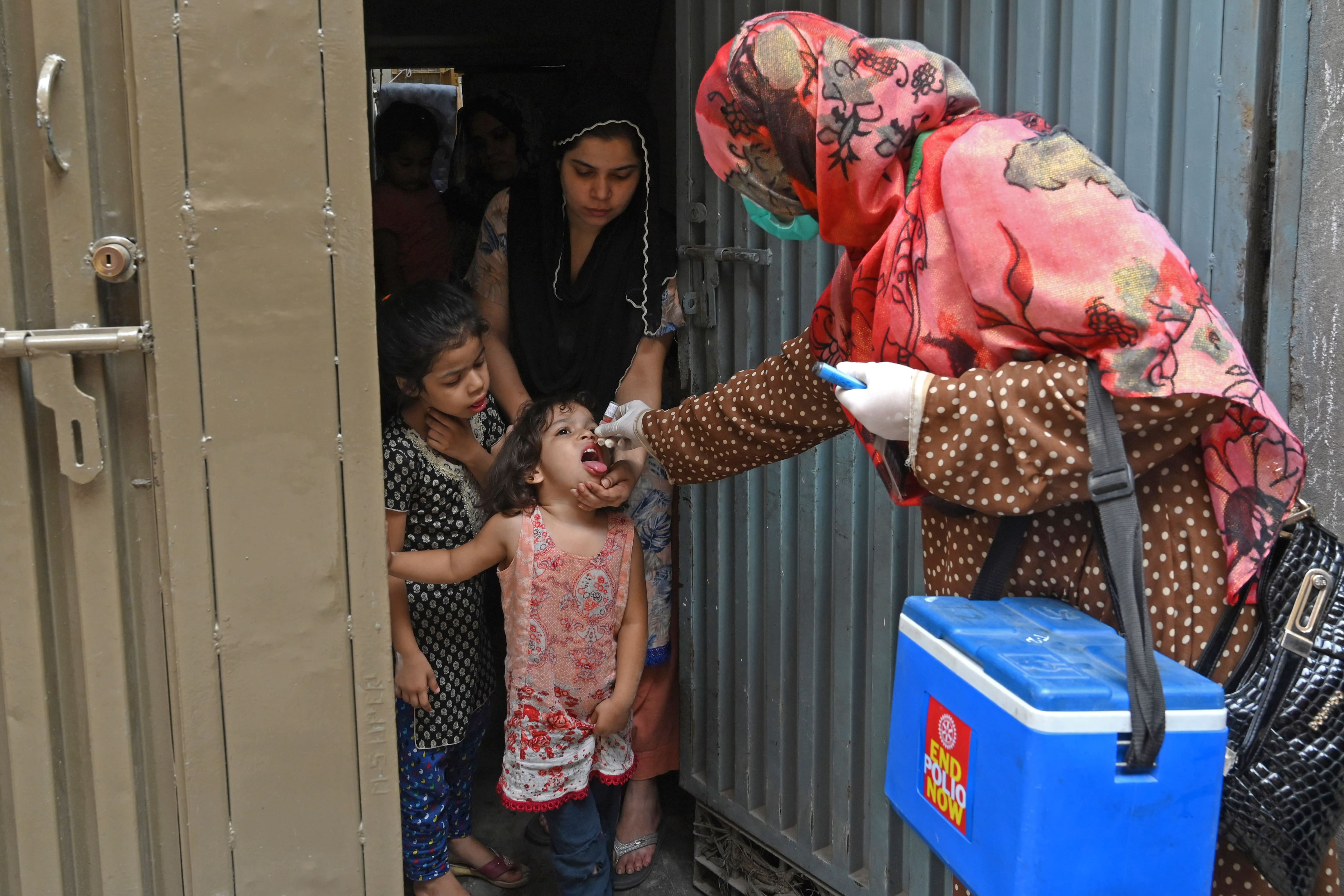 A health worker administers polio vaccine drops to a child during a polio vaccination door-to-door campaign in Lahore on July 20, 2020. (AFP)