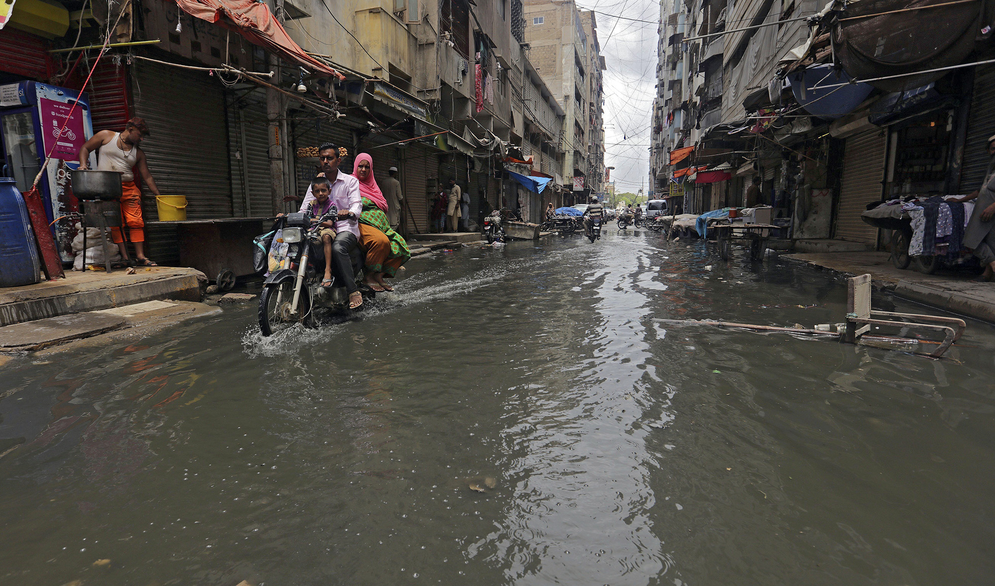 A motorcyclist drives through a street flooded by heavy rainfall in Karachi on Aug. 9, 2020. (AP)