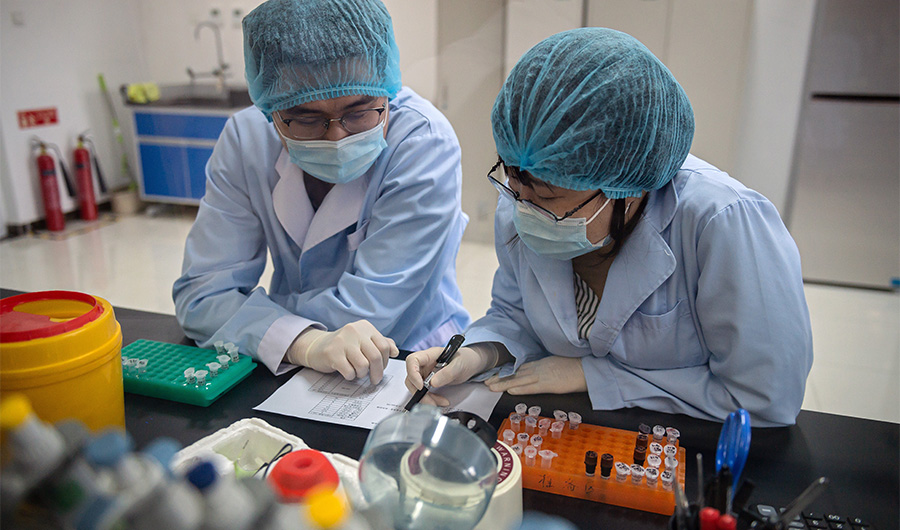 Workers are seen inside the Beijing Applied Biological Technologies (XABT) research and development laboratory in Beijing on May 14, 2020. (AFP)