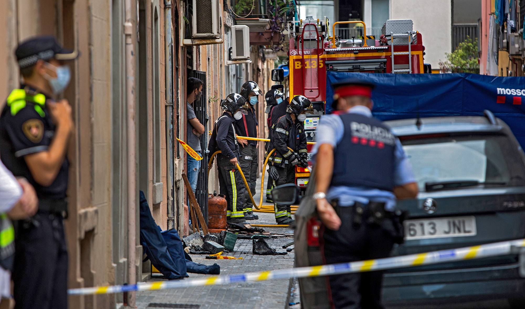 Firefighters gather outside an apartment building that caught fire in the Barceloneta neighborhood of Barcelona on Aug. 14, 2020. Three Pakistanis were killed in the fire, and four people were injured, including one seriously, local authorities said. (AFP)