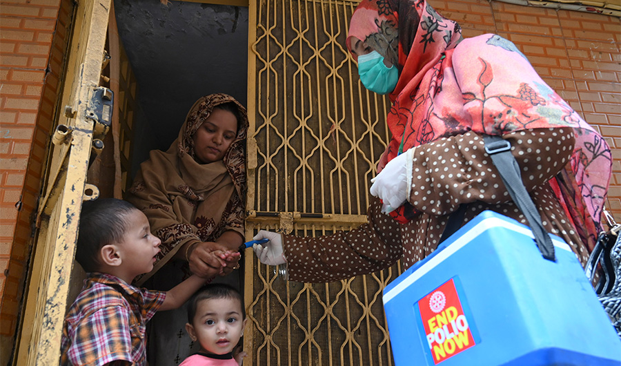 A health worker (R) marks the finger of a child after administering polio vaccine drops during a polio vaccination door-to-door campaign in Lahore on July 20, 2020. (AFP)