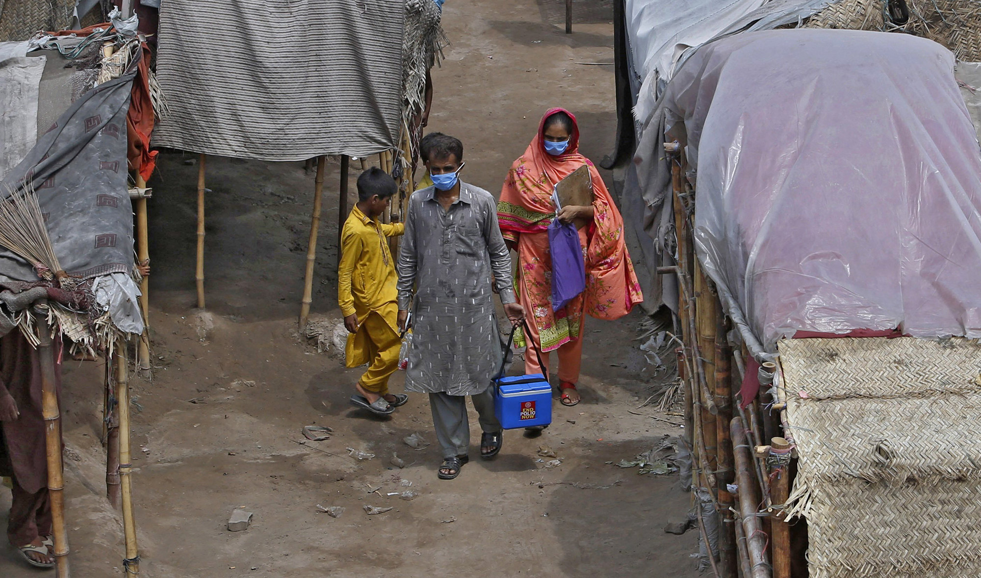 Health workers visit a slum area for polio vaccination in Lahore on Aug. 15, 2020. (AP)